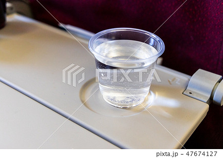 Inflight cabin glass of water on table.  47674127