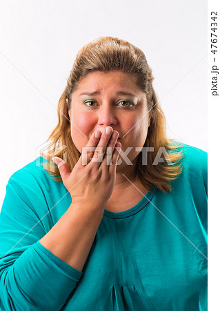 Worried woman with her hand over mouth Worried woman with her hand over mouth 47674342