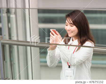 笑顔でスマホを見るビジネスウーマン 47675132