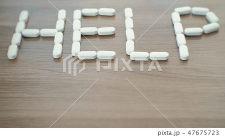 word - help consists of pills on the table. 47675723