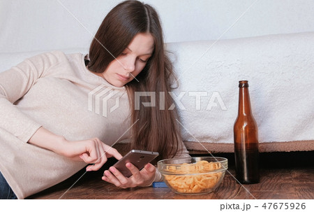Sad young beautiful brunette woman typing a message on the mobile phone. Sad young beautiful brunette woman typing a message on the mobile phone. 47675926