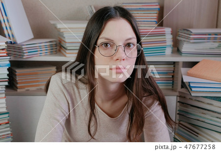 Young brunette woman in glasses is thinking. Young brunette woman in glasses is thinking. 47677258