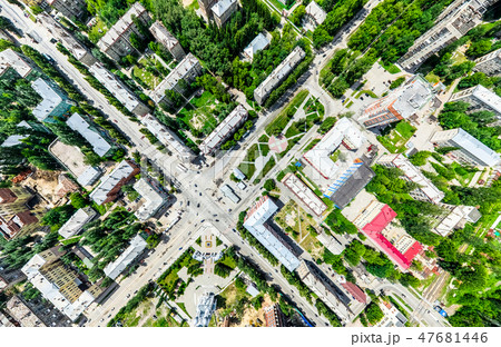 Aerial city view with crossroads and roads, houses, buildings, parks and parking lots. Sunny summer Aerial city view with crossroads and roads, houses, buildings, parks and parking lots. Sunny summer 47681446