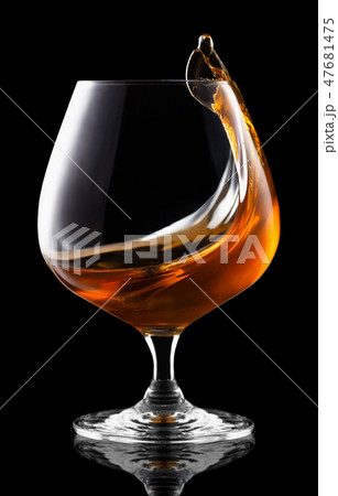 splash of brandy in snifter glass 47681475