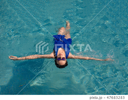 asian girl with swimming suite and sun glasses on pool 47683283