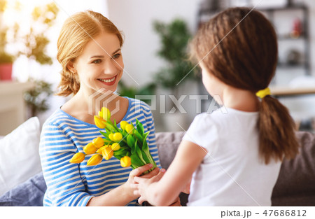 happy mother's day! child gives mother a bouquet 47686812
