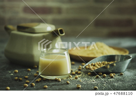 Soymilk in the glass and the kettle placed beside. Soymilk in the glass and the kettle placed beside. 47688110