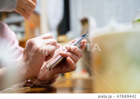 スマホを持つシニア女性 手元 47689442