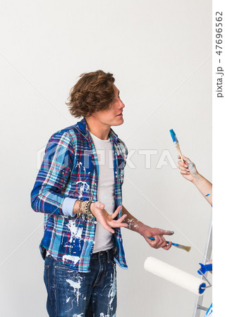 People, renovation and redecoration concept - Young woman and man discussing new apartment 47696562