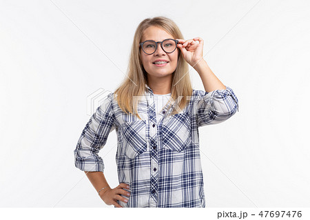 Teeth health, dentistry and bite correction - Happy smiling woman in glasses with braces on white Teeth health, dentistry and bite correction - Happy smiling woman in glasses with braces on white 47697476