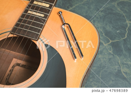 Acoustic guitar and tuning fork 47698389