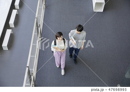 大学 キャンパスライフ 大学構内を歩く男女学生の写真素材