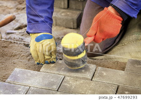 Paving the tiles on the sidewalk Paving the tiles on the sidewalk 47699293