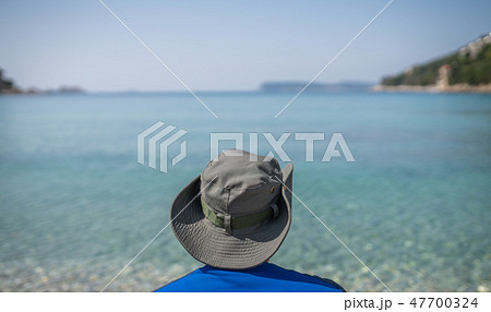 Tourist with a hat on a sea shore 47700324