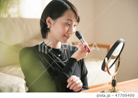 メイクブラシで化粧をする若い日本人女性 メイクブラシで化粧をする若い日本人女性 47700400
