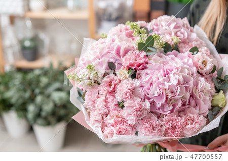 beautiful fresh cut bouquet of mixed flowers in woman hand. the work of the florist at a flower shop 47700557