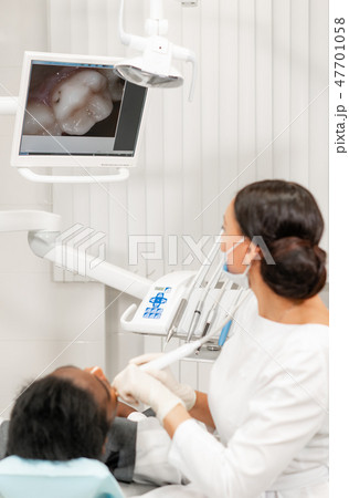 Inspection with a dental macro camera and displays the result on the monitor. Young woman dentist Inspection with a dental macro camera and displays the result on the monitor. Young woman dentist 47701058