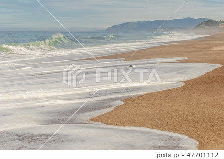 Big breaking Ocean wave on a sandy beach on the north shore of Oahu Hawaii 47701112