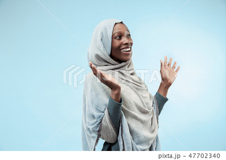 The beautiful young black muslim girl wearing gray hijab, with a happy smile on her face. 47702340