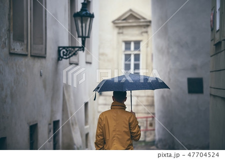 Lonely man with umbrella in rain Lonely man with umbrella in rain 47704524