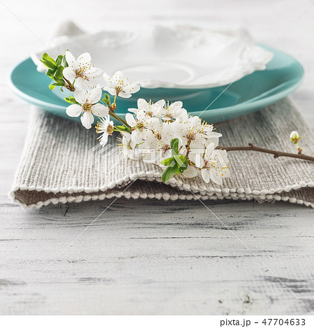 Spring table set with plates and white flowers 47704633