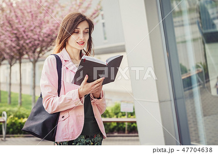 Woman portrait over pink blooming trees outside Woman portrait over pink blooming trees outside 47704638