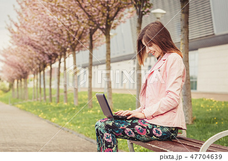 Woman portrait over pink blooming trees outside Woman portrait over pink blooming trees outside 47704639