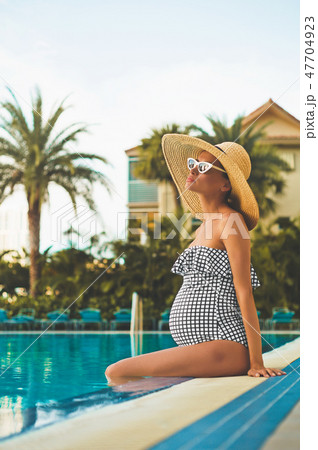 Beautiful pregnant woman in swimming pool 47704923