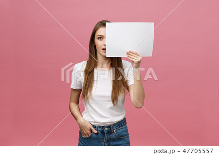 Young caucasian woman holding blank paper sheet over isolated background scared in shock with a 47705557