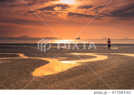 Silhouette of young man standing on golden beach Silhouette of young man standing on golden beach 47706540