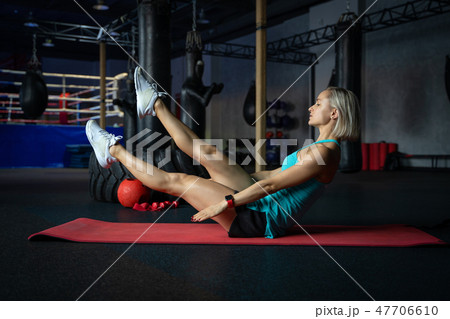 Young attractive cool woman practicing abs exercise, Sit Ups, working out, wearing sportswear, full Young attractive cool woman practicing abs exercise, Sit Ups, working out, wearing sportswear, full 47706610