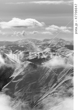 Black and white snowy sunlight mountains in haze 47706647