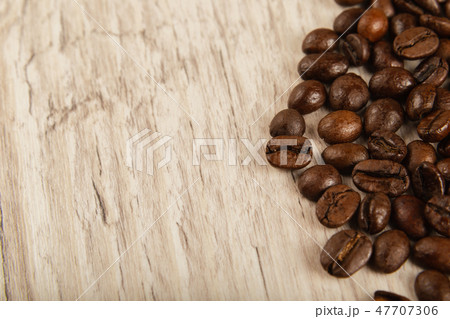 Grains of coffee on a wooden background in large 47707306