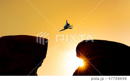Silhouette a man jumping over precipice Silhouette a man jumping over precipice 47708698