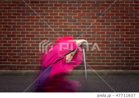 Little girl riding fast on her scooter 47711637