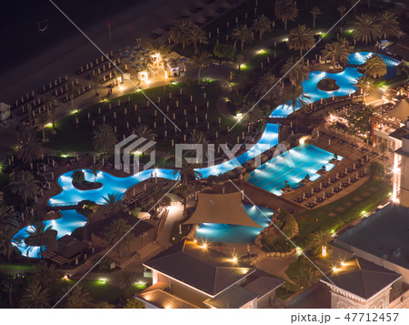Beach coast with open pool hotels in Dubai. View from the height at night Beach coast with open pool hotels in Dubai. View from the height at night 47712457