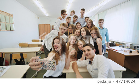 Young happy cheerful students making selfie in school class. Young happy cheerful students making selfie in school class. 47714024