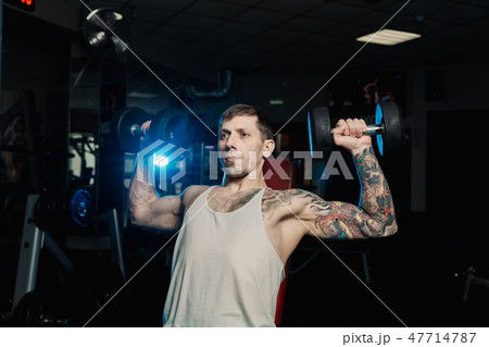 Handsome athletic man training his shoulders with 47714787