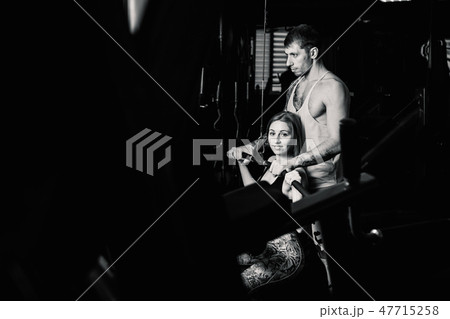 Handsome athletic man helps a beautiful girl to Handsome athletic man helps a beautiful girl to 47715258