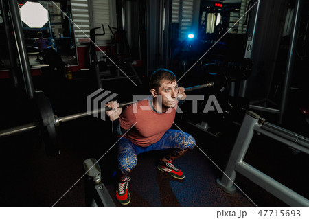 Handsome athletic man doing a squat in the gym. 47715693