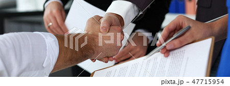 Man in suit and tie give hand as hello in office closeup Man in suit and tie give hand as hello in office closeup 47715954