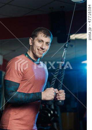 Handsome athletic man trains triceps on the block Handsome athletic man trains triceps on the block 47716384