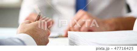Clerk man at office workplace with silver pen in arms 47716425