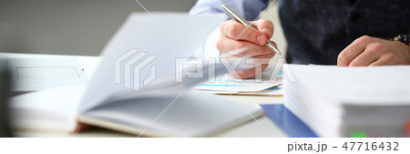 Clerk man at office workplace with silver pen in arms 47716432