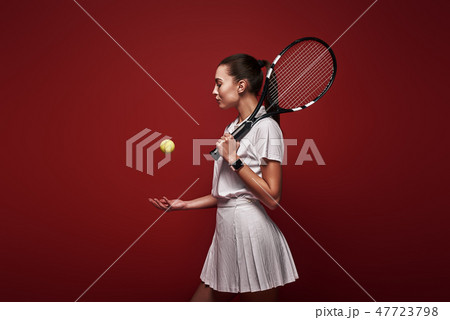 Talk with your raquet, play with your heart. Young tennis player standing isolated over red Talk with your raquet, play with your heart. Young tennis player standing isolated over red 47723798