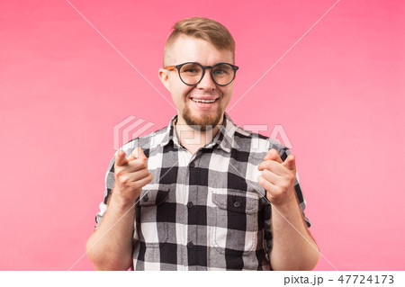 Young man with beard, finger pointing towards the camera on a pink background Young man with beard, finger pointing towards the camera on a pink background 47724173