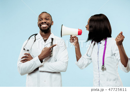 The female and male happy afro american doctors on blue background 47725611