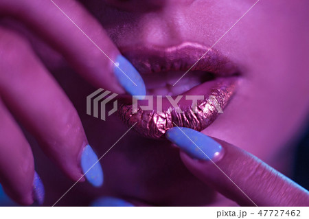 Stylish girl Model with golden lips and bright nails. 47727462