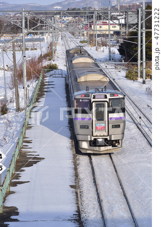 冬の朝の北海道七飯町大中山駅に列車「はこだてライナー」が停車、通過する風景を撮影 47731222