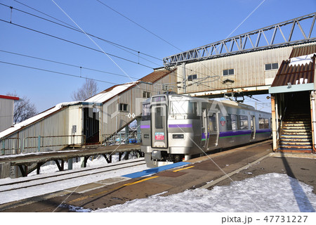 冬の朝の北海道七飯町大中山駅に列車「はこだてライナー」が停車、通過する風景を撮影 47731227